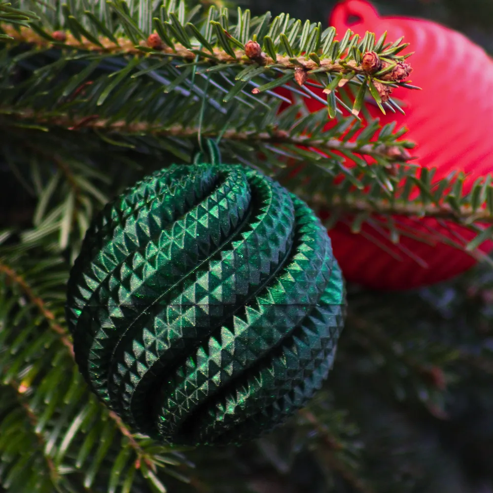Bola de Natal verde texturizada pendurada num pinheiro