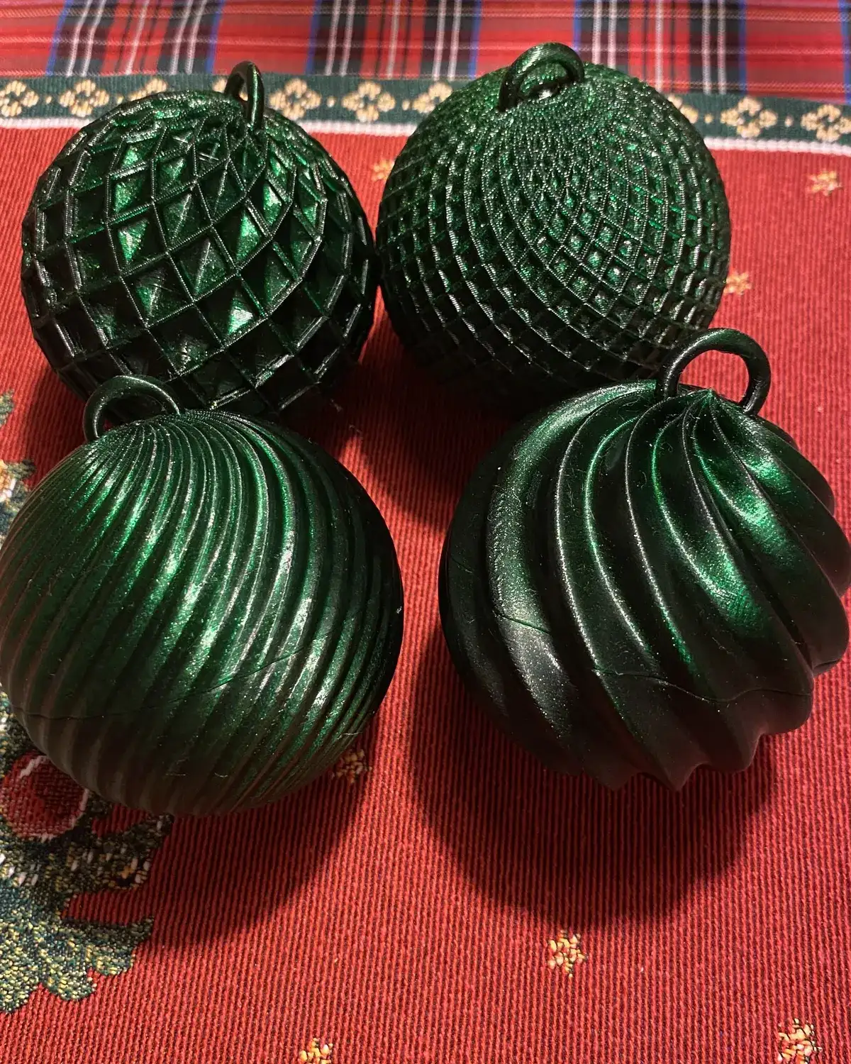 Bolas de Natal verdes texturizadas sobre toalha vermelha